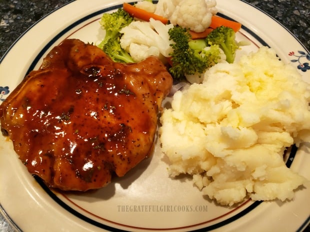 The finished pork chops are served with glaze spooned over the top of each piece.