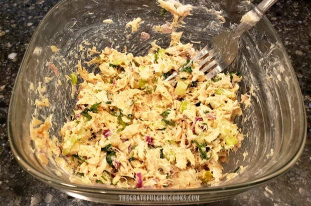 All the ingredients for the classic tuna salad are mixed together in bowl.