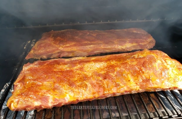 Smoking the baby back ribs on a Traeger grill for 3 hours.