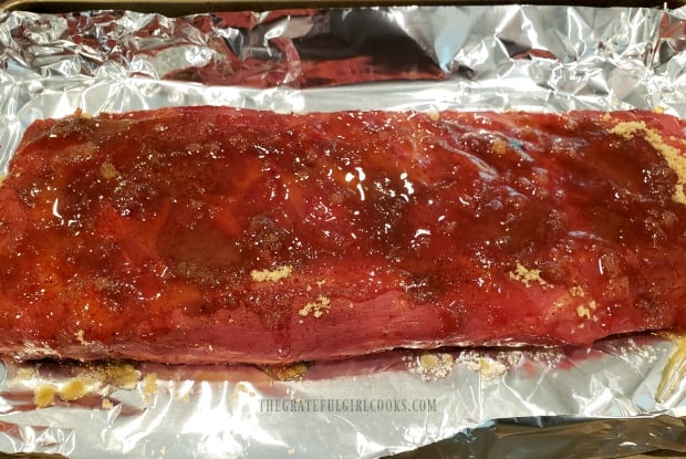 BBQ Baby Back Ribs are covered in brown sugar and honey with apple juice in foil.