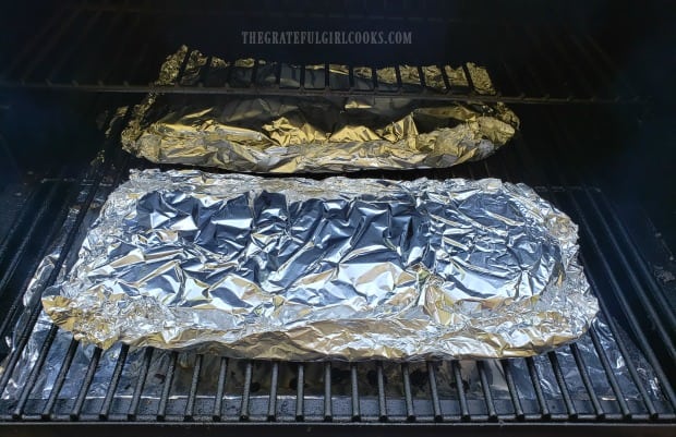 Foil packets with the ribs are cooked on the grill for two hours.
