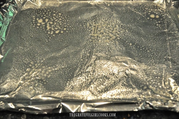 A baking sheet is covered with foil, and coated with non-stick baking spray.