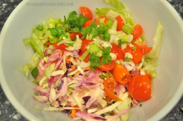 Topping for the baja fish tacos includes cabbage, lettuce, tomatoes, and green onions.