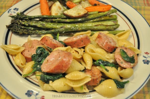 Chicken sausage and spinach pasta, on a plate with roasted veggies.