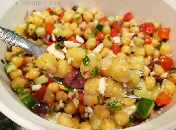 A bite of the Greek garbanzo salad on a fork, ready to eat.