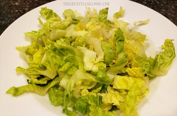 Chopped romaine lettuce in a white bowl, ready for all the toppings.