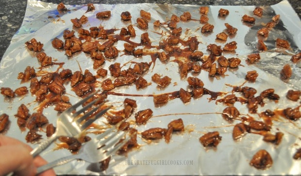 The candied pecans drying on aluminum foil.