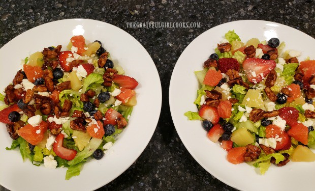 An overhead look at the fruit feta green salad prepared for two people.