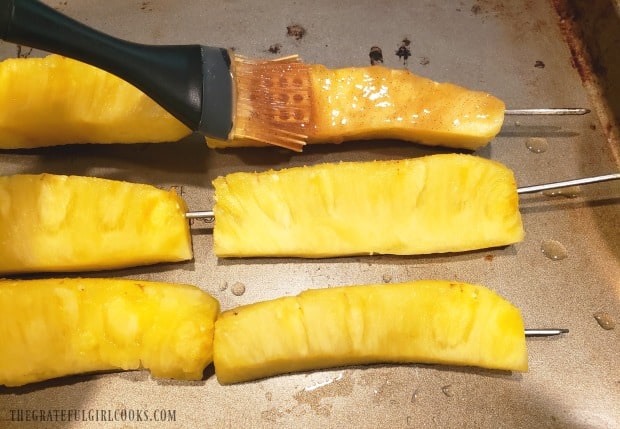 The brown sugar & cinnamon glaze is brushed onto pineapple spears before cooking.