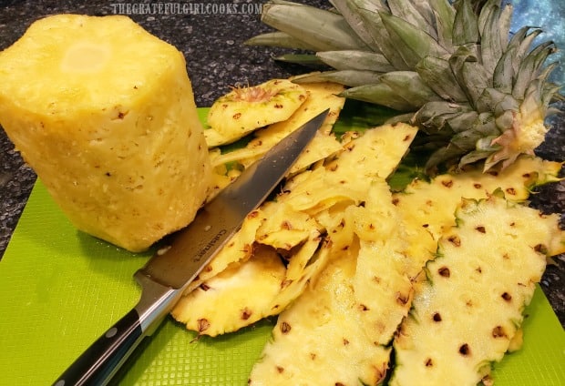 All the peel and brown "eyes" are cut out of the pineapple before slicing.