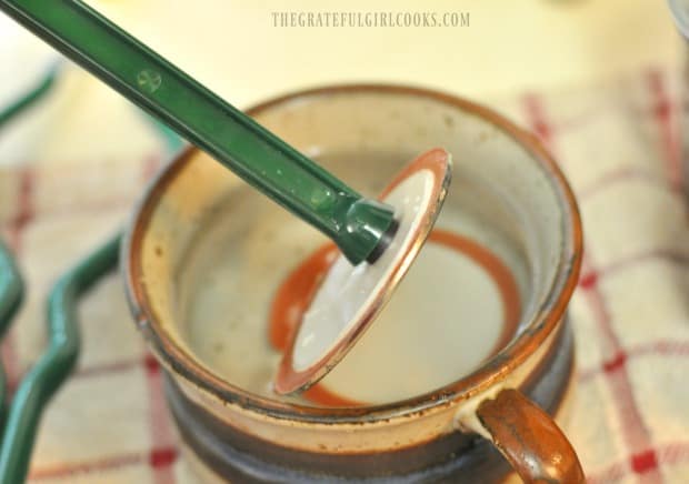 A flat lid is ready to place on a filled canning jar, before processing.