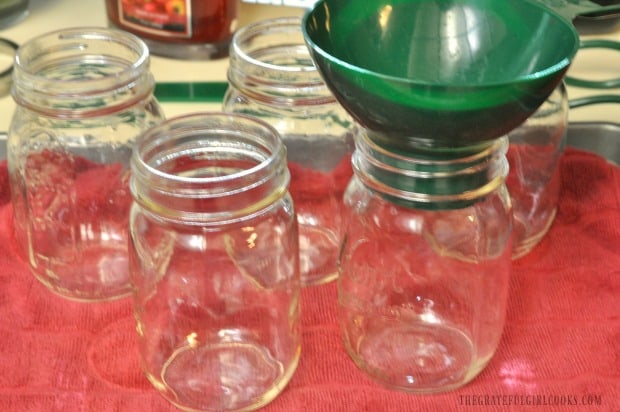 Canning jars and funnel used to pour asparagus into jars.