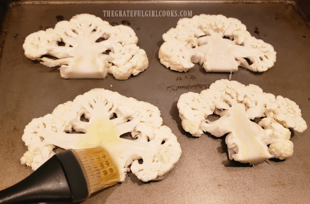 Each piece of cauliflower is basted with olive oil on both sides.