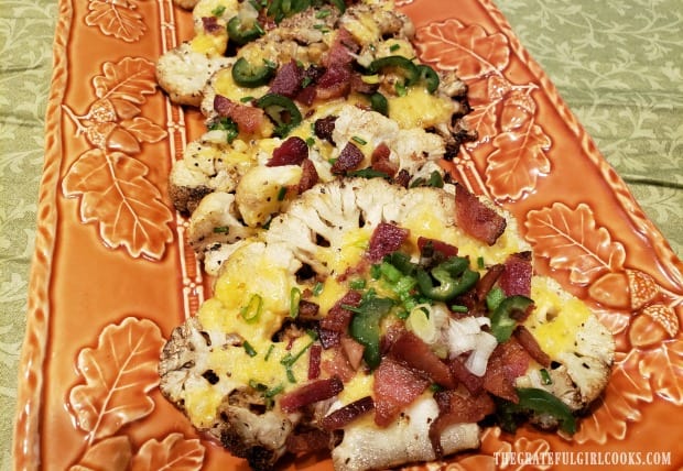 All of the loaded grilled cauliflower on a serving platter.