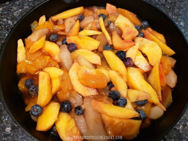 Fruit for the cobbler is poured into a 9" skillet after mixing together.