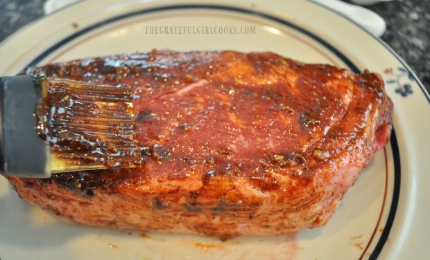 A pastry brush applies the chili rub to the rib eye steaks.