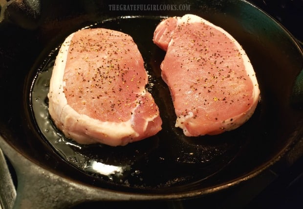Seasoned chops are pan-seared in olive oil in a hot skillet.
