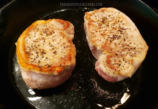 Pork chops are turned to cook other side after turning golden brown.