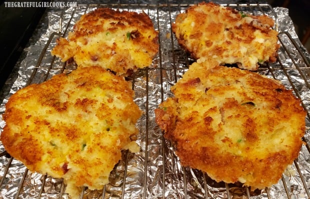 Mashed potato loaded fritters draining on wire rack after removing from hot oil.