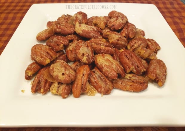 A white serving plate with the sugared curry ginger pecans on it, ready to eat!