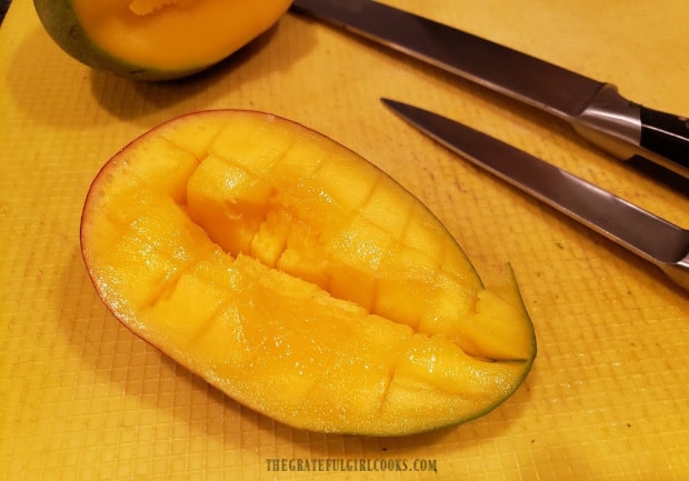 Mango is sliced into cubes before adding them to salsa.