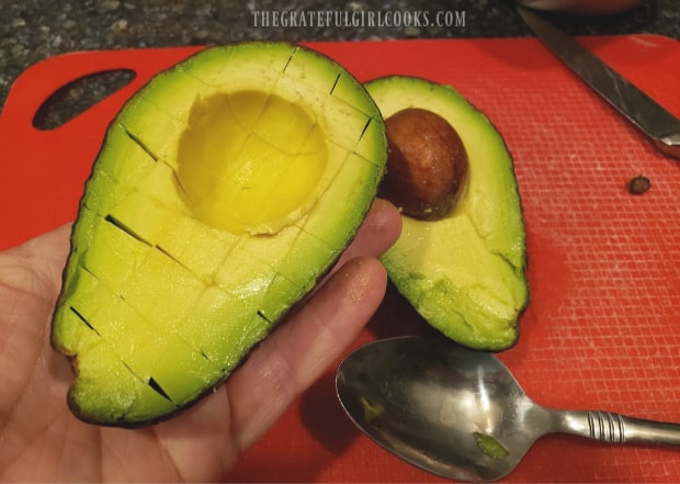Avocados are halved, then cut into cubes to add to the salsa.