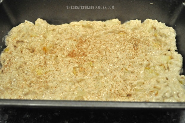 Thick batter is placed into a greased loaf pan for baking.