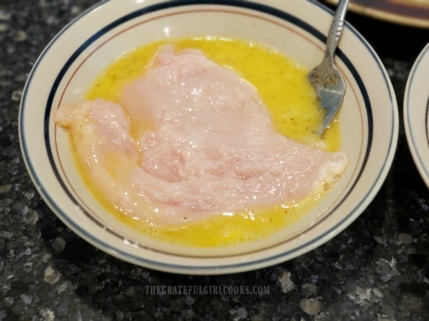 Each chicken breast is covered with a beaten egg mixture.