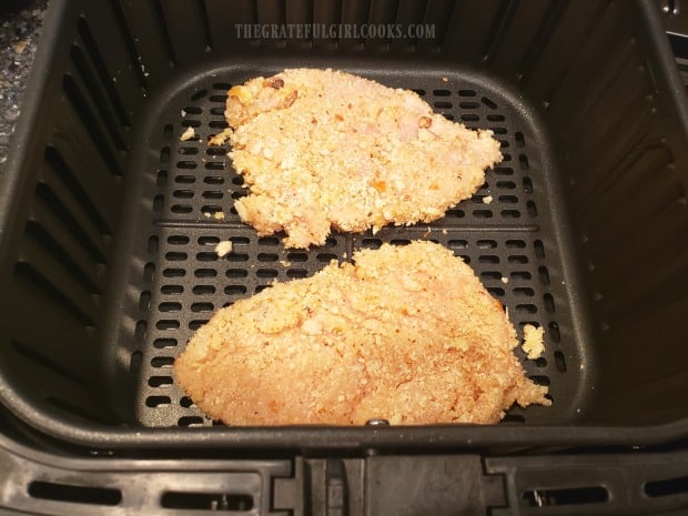 Bread crumb coated chicken breasts cook in an air fryer for 5 minutes.