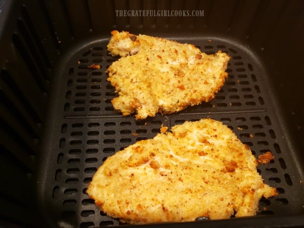 Chicken breasts are flipped over, after cooking in an air fryer for 5 minutes.