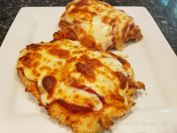 Two pieces of air fryer chicken parmesan on a plate, ready to eat!