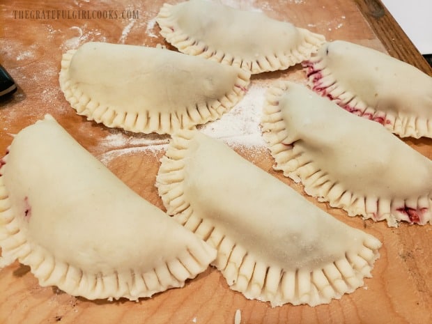 Dough is folded over the pie filling, and edges are crimped to seal.