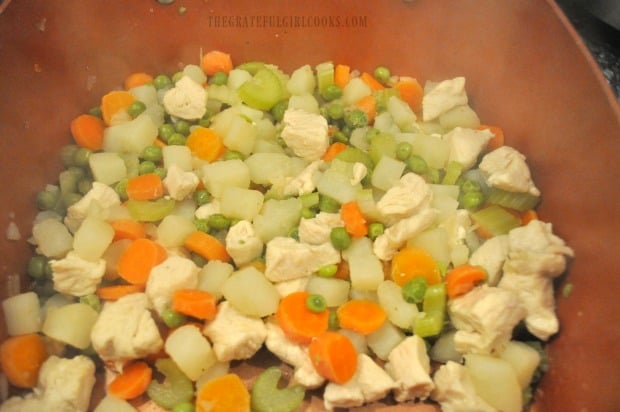 Drained veggies and chicken in saucepan, waiting for thickened sauce.