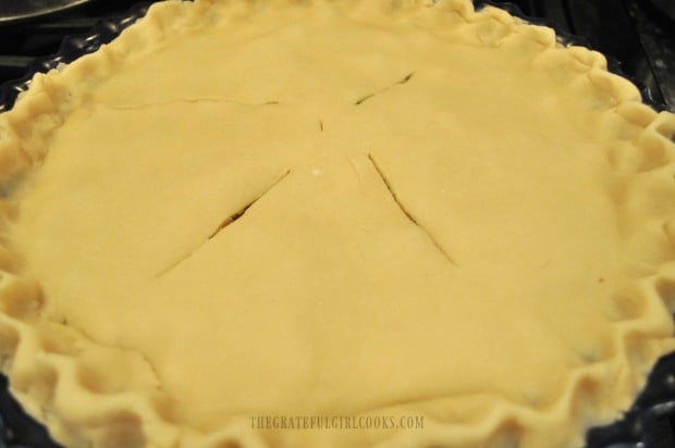 Another pie crust is added to the top of the chicken pot pie and sealed before baking.