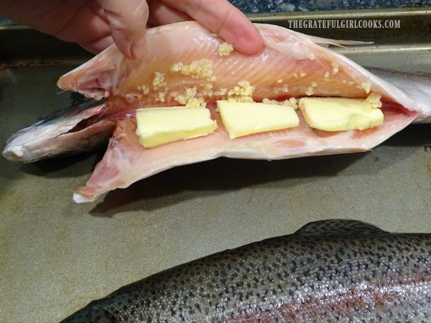 Minced garlic and thin slices of butter are added to the fish cavity.