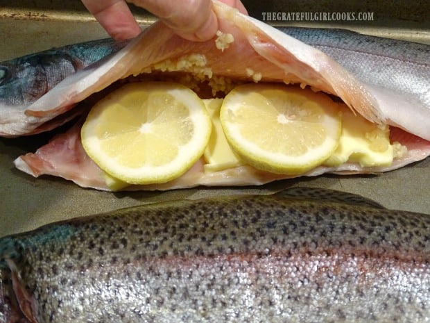 Thin lemon slices are added to the garlic and butter in the fish cavity.