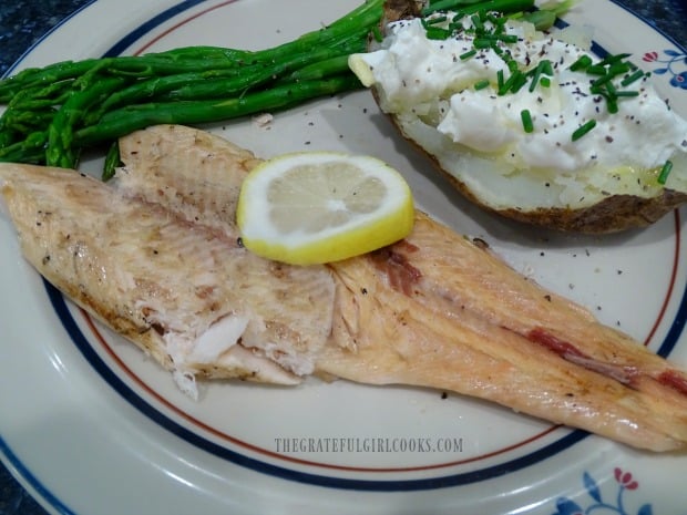 Garlic butter grilled trout fillet, served with a baked potato and asparagus.