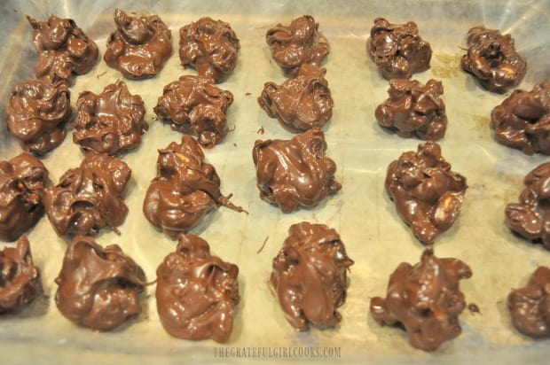 Two dozen chocolate cashew cranberry bites on wax paper.