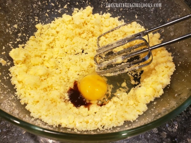 An egg and vanilla are added to creamed cake batter mixture.