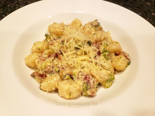 The gnocchi and broccoli carbonara is garnished with grated Parmesan cheese.