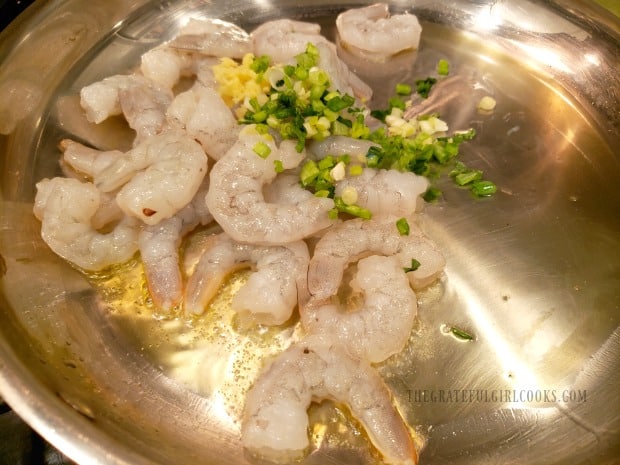 The shrimp are cooked in hot oil, with garlic, green onion, and ginger.