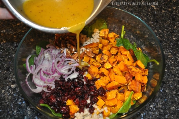 Vinaigrette is poured over the Thanksgiving salad, and salad is tossed before serving.