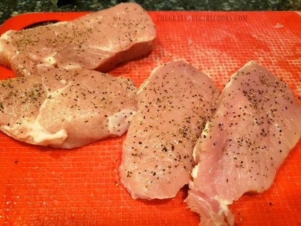 Boneless pork chops are lightly seasoned with salt and pepper.
