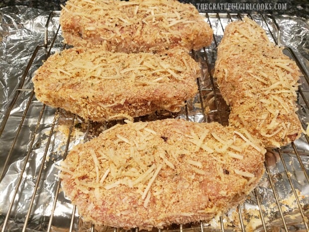 Four easy baked pork chops on a wire rack are ready for the oven!