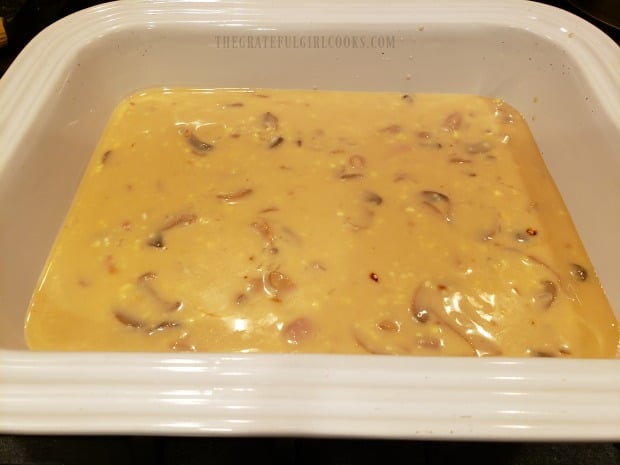 Sauce for the easy chicken rice casserole is spread into a baking dish.