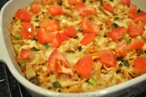 Once done baking, the turkey fiesta casserole is topped with chopped tomatoes before serving.