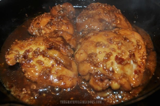 Some of the Asian sauce is spooned on top of chicken thighs before serving.