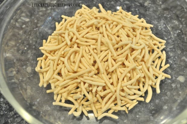 Crunchy chow mein noodles are measured into mixing bowl.