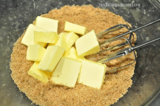 Butter is mixed into the brown and granulated sugars in bowl.