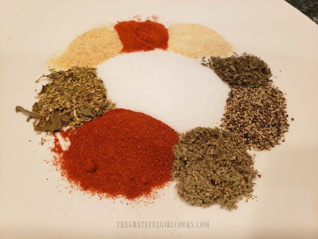 Poultry seasoning ingredients measured out on a white plate.